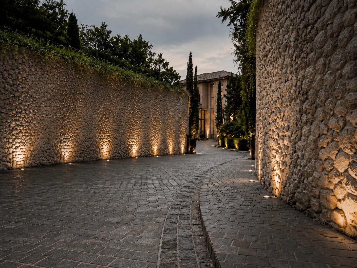 Stone driveway between textured stone walls